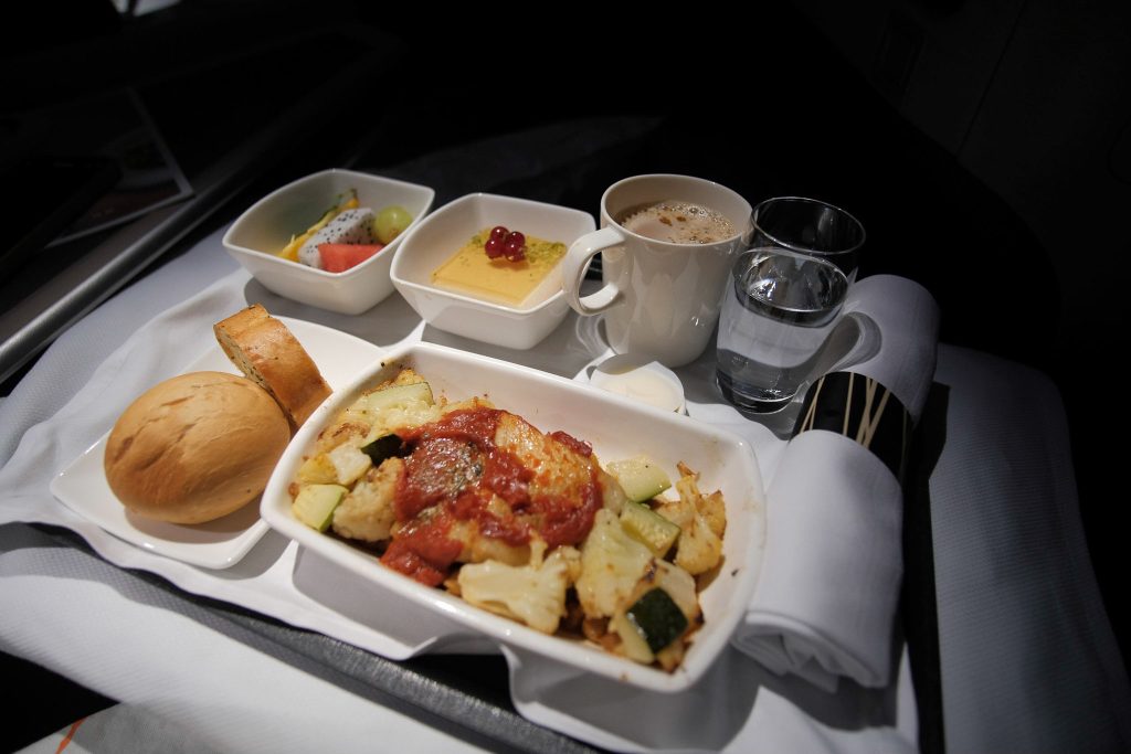 Baked spiced barramundi with tomato harissa sauce meal on the Cathay Pacific A350-900 flight.